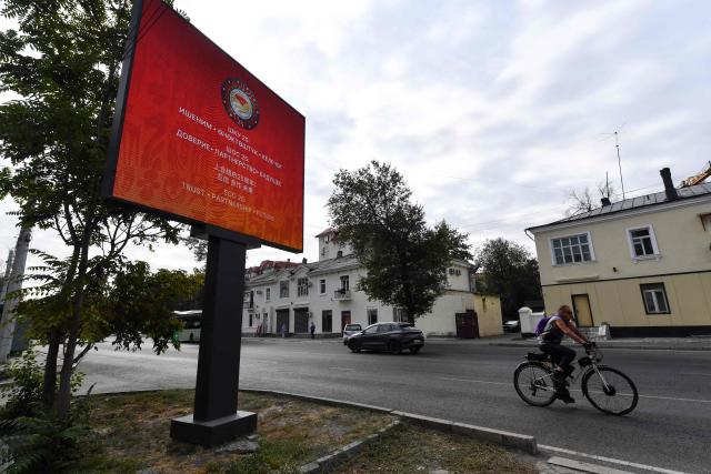 A man rides a bicycle past an advertising screen displaying the Shanghai Cooperation Organisation (SCO) summit related images in Bishkek on September 1, 2026. (Photo by Vyacheslav OSELEDKO / AFP)