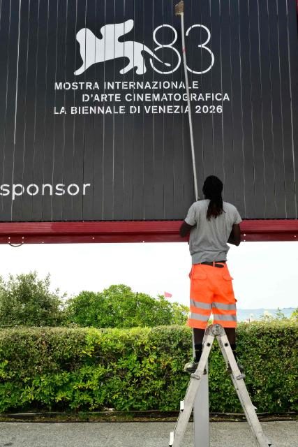 A man cleans an advertising board displaying the logo of the 83Rd Venice Film Festival, at Venice Lido on September 1, 2026. (Photo by Stefano RELLANDINI / AFP)