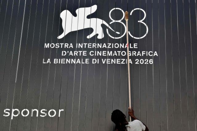 A man cleans an advertising board displaying the logo of the 83Rd Venice Film Festival, at Venice Lido on September 1, 2026. (Photo by Stefano RELLANDINI / AFP)