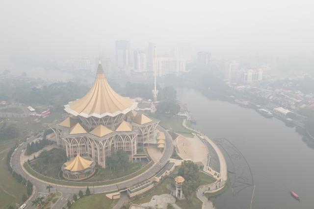 An aerial view shows haze shrouding the area around the Sarawak Legislative Assembly building (L) in Kuching, the capital city of Sarawak state on the island of Borneo on September 1, 2026. Air quality in Malaysia's Sarawak state deteriorated further on September 1 as smoke from Indonesian forest fires drove up respiratory complaints and sent residents scrambling for protective masks. (Photo by AFP)