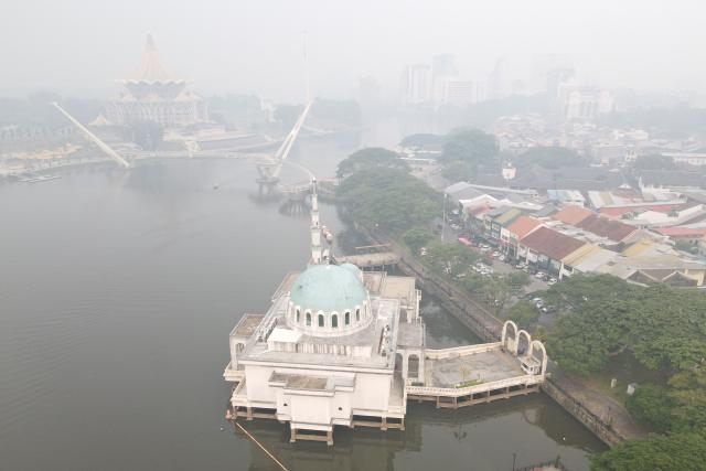 An aerial view shows haze shrouding the area around the Sarawak Legislative Assembly building (top) in Kuching, the capital city of Sarawak state on the island of Borneo on September 1, 2026. Air quality in Malaysia's Sarawak state deteriorated further on September 1 as smoke from Indonesian forest fires drove up respiratory complaints and sent residents scrambling for protective masks. (Photo by AFP)