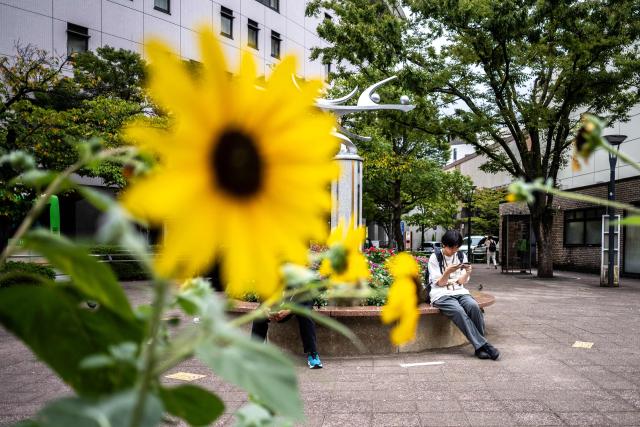 People sit in front of Funabori metro station in Tokyo on September 1, 2026. (Photo by Philip FONG / AFP)