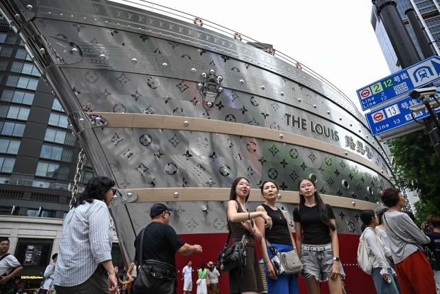 People walk past the "The Louis", a large ship-shaped structure of the Louis Vuitton brand in Shanghai on September 1, 2026. (Photo by Jade GAO / AFP)