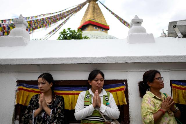Nepalese women offer prayers during a vigil to pay tribute to the flash flood victims at the Boudhanath Stupa in Kathmandu on September 1, 2026. (Photo by Manan VATSYAYANA / AFP)
