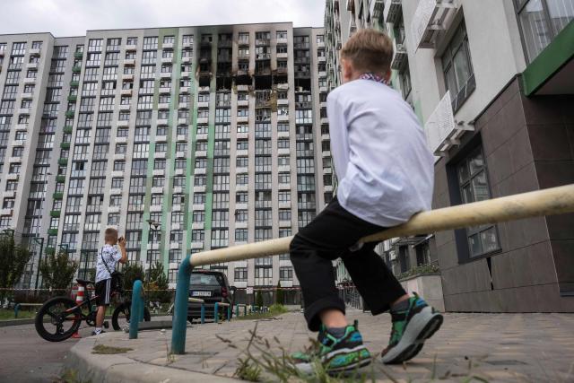Boys look at a heavily damaged residential building following a Russian strike in Kyiv on September 1, 2026, amid the Russian invasion of Ukraine. Russia launched a barrage of drones and ballistic missiles at Kyiv and its surrounding region overnight, killing at least 12 people and wounding 21, Ukraine said on September 1, 2026, hitting the capital as children were set to return to school after the summer. (Photo by Vladyslav Musiienko / AFP)