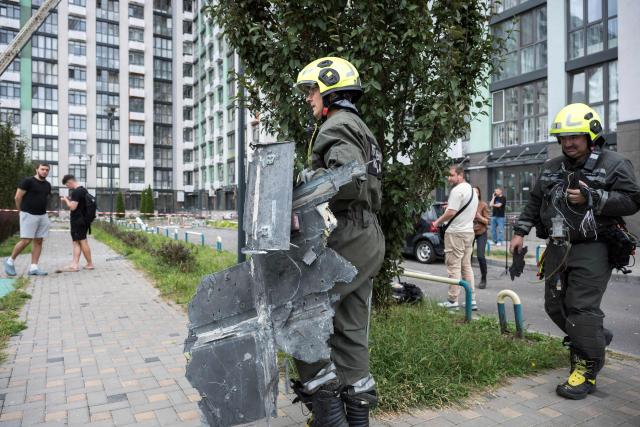 A rescuer carries part of the wreckage of an alleged Russian drone following a Russian strike in Kyiv on September 1, 2026, amid the Russian invasion of Ukraine. Russia launched a barrage of drones and ballistic missiles at Kyiv and its surrounding region overnight, killing at least 12 people and wounding 21, Ukraine said on September 1, 2026, hitting the capital as children were set to return to school after the summer. (Photo by Vladyslav Musiienko / AFP)