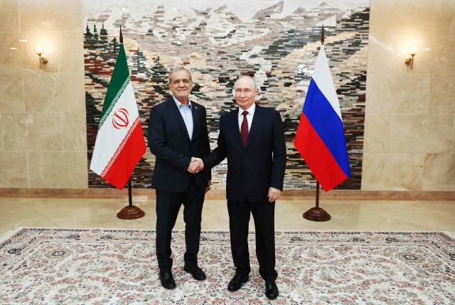In this pool photograph distributed by the Russian state agency Sputnik, Russia's President Vladimir Putin and Iran's President Masoud Pezeshkian shake hands during a meeting on the sidelines of the Shanghai Cooperation Organisation (SCO) summit in Bishkek on September 1, 2026. (Photo by Kristina Solovyova / POOL / AFP)