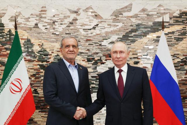 In this pool photograph distributed by the Russian state agency Sputnik, Russia's President Vladimir Putin and Iran's President Masoud Pezeshkian shake hands during a meeting on the sidelines of the Shanghai Cooperation Organisation (SCO) summit in Bishkek on September 1, 2026. (Photo by Vyacheslav PROKOFYEV / POOL / AFP)