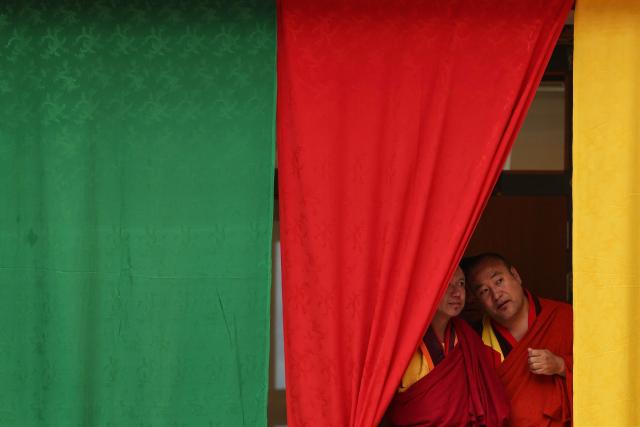 Monks peek from behind the curtains during the Global Conscious Food Systems Summit in Paro, Bhutan, on September 1, 2026. (Photo by Niharika KULKARNI / AFP)