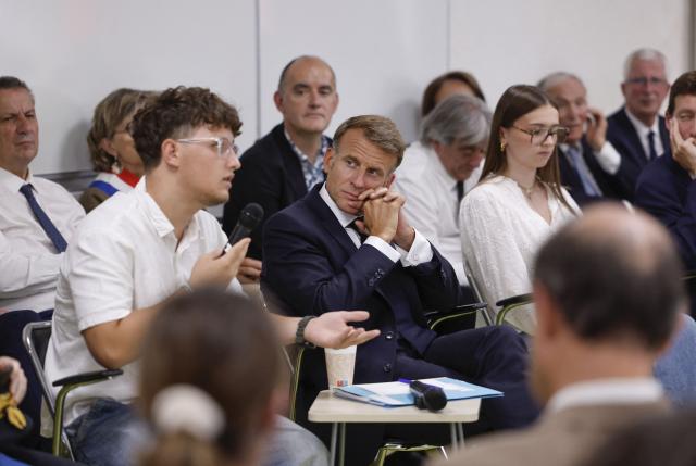 France's President Emmanuel Macron (C) speaks with with students during a visit to the INSPE University on the first day of the new academic year in Mende, southern France on September 1, 2026. Some 11.6 million primary, middle and secondary school pupils are returning to school on September 1, 2026, with headteachers' preparations having been disrupted by the fallout from a cyberattack targeting the French Ministry of Education this summer. Among the main changes this year are a ban on mobile phones in sixth-form colleges and the distribution to all pupils, from the final year of nursery school to the final year of sixth form, of a questionnaire on gender-based and sexual violence. (Photo by Guillaume HORCAJUELO / POOL / AFP)