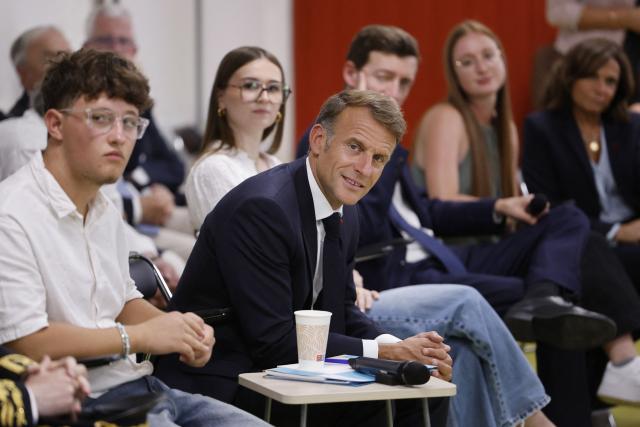 France's President Emmanuel Macron (C) speaks with with students during a visit to the INSPE University on the first day of the new academic year in Mende, southern France on September 1, 2026. Some 11.6 million primary, middle and secondary school pupils are returning to school on September 1, 2026, with headteachers' preparations having been disrupted by the fallout from a cyberattack targeting the French Ministry of Education this summer. Among the main changes this year are a ban on mobile phones in sixth-form colleges and the distribution to all pupils, from the final year of nursery school to the final year of sixth form, of a questionnaire on gender-based and sexual violence. (Photo by Guillaume HORCAJUELO / POOL / AFP)