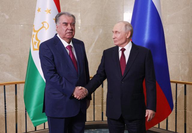 In this pool photograph distributed by the Russian state agency Sputnik, Russia's President Vladimir Putin and Tajikistan's President Emomali Rakhmon shake hands during a meeting on the sidelines of the Shanghai Cooperation Organisation (SCO) summit in Bishkek on September 1, 2026. (Photo by Vyacheslav PROKOFYEV / POOL / AFP)