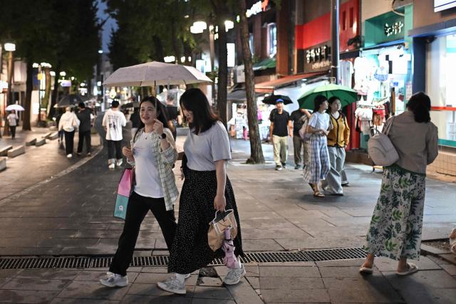 Pedestrians walk along Insadong street in Seoul on September 1, 2026. (Photo by Lillian SUWANRUMPHA / AFP)
