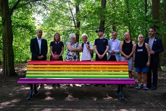 (FILES) People, including Stefanie Remlinger (3rd L), mayor of Berlin's Mitte district, unveil a rainbow colored park bench, in tribute to the victims at the Tiergarten park in Berlin on August 6, 2026, after a car ramming attack that killed one person and injured 29 near the Christopher Street Day (CSD) parade. The commemorative bench for the car ramming attack victims of the CSD has been vandalized and then removed on September 1, 2026 in Berlin. (Photo by John MACDOUGALL / AFP)