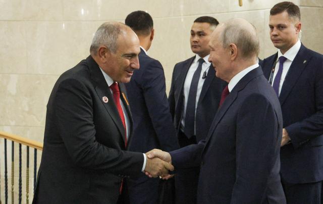 In this pool photograph distributed by the Russian state agency Sputnik, Russia's President Vladimir Putin and Armenian Prime Minister Nikol Pashinyan shake hands after a meeting on the sidelines of the Shanghai Cooperation Organisation (SCO) summit in Bishkek on September 1, 2026. (Photo by Vyacheslav PROKOFYEV / POOL / AFP)