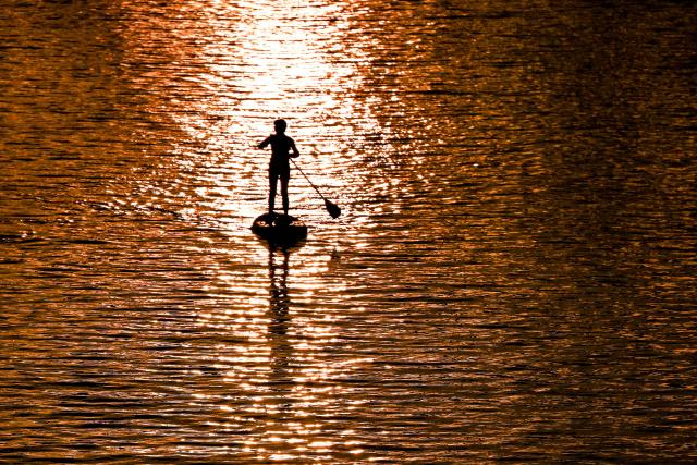 A person paddles on a SUP board on the Main river during the sunset in Frankfurt am Main, western Germany, on September 1, 2026, as air temperatures reached 22 degrees Celsius. (Photo by Kirill KUDRYAVTSEV / AFP)