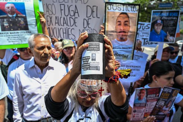 A relative of political prisoners holds a poster featuring Venezuelan Interior Minister Diosdado Cabello reading "Wanted by the US government" during the "How Much Oil Do Our Prisoners Cost?" march outside the Ministry of Prisons in Caracas on September 1, 2026. Relatives of political prisoners demonstrate in Caracas on September 1, calling on Washington over the failure to secure the release of their detained loved ones, as a major oil agreement between the United States and Venezuela takes shape. (Photo by Juan BARRETO / AFP)