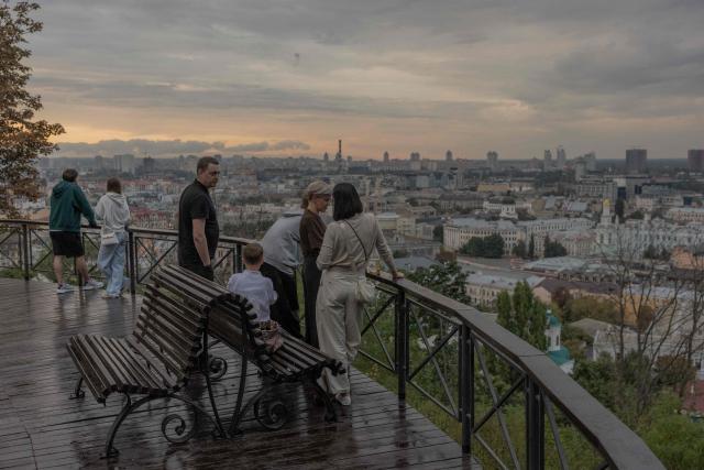 People look out over the Podil neighborhood from an observation area during an air raid alert, in Kyiv on September 1, 2026, amid the Russian invasion of Ukraine. (Photo by Roman PILIPEY / AFP)