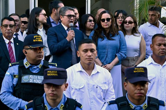 Former Honduran president Juan Orlando Hernandez (2014-2022) speaks to the press alongside his wife Ana Garcia (C, right) as police officers stand guard outside the Supreme Court of Justice in Tegucigalpa on September 1, 2026, after a judge dismissed corruption charges against him. Honduran justice on September 1 dismissed corruption charges against former president Juan Orlando Hernandez, who had previously been pardoned by US President Donald Trump following a drug trafficking conviction in the United States, the judiciary said. (Photo by Orlando SIERRA / AFP)