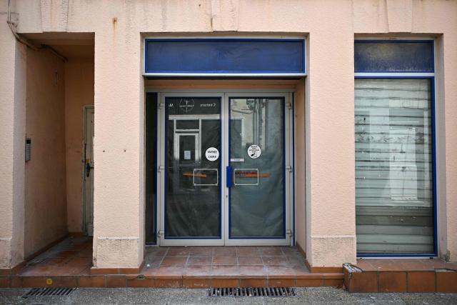 This photograph shows the storefront of a closed business in Saint-Gaudens, where commercial vacancy has increased over the past ten years on July 29, 2026. 'For sale', 'to let', 'potential to convert into a home': the streets of Saint-Gaudens' old town are dotted with closed-down commercial premises, whilst this town of just over 12,000 inhabitants at the foot of the Pyrenees fears losing its paper pulp mill and the hundreds of jobs it provides. "Watchmaker and jeweller", "quick alterations", "hairdresser", "optician"  these are the signs visible on some of the abandoned shop fronts, giving a clue as to what sort of business once occupied the premises. In other cases, there is no trace left of the former business. Some shop windows are even completely covered by posters of all kinds, including some dating back several years, such as one calling for a protest against the 2023 pension reforms. (Photo by Lionel BONAVENTURE / AFP)