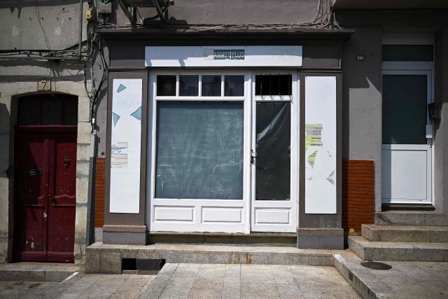This photograph shows the storefront of a closed business in Saint-Gaudens, where commercial vacancy has increased over the past ten years on July 29, 2026. 'For sale', 'to let', 'potential to convert into a home': the streets of Saint-Gaudens' old town are dotted with closed-down commercial premises, whilst this town of just over 12,000 inhabitants at the foot of the Pyrenees fears losing its paper pulp mill and the hundreds of jobs it provides. "Watchmaker and jeweller", "quick alterations", "hairdresser", "optician"  these are the signs visible on some of the abandoned shop fronts, giving a clue as to what sort of business once occupied the premises. In other cases, there is no trace left of the former business. Some shop windows are even completely covered by posters of all kinds, including some dating back several years, such as one calling for a protest against the 2023 pension reforms. (Photo by Lionel BONAVENTURE / AFP)