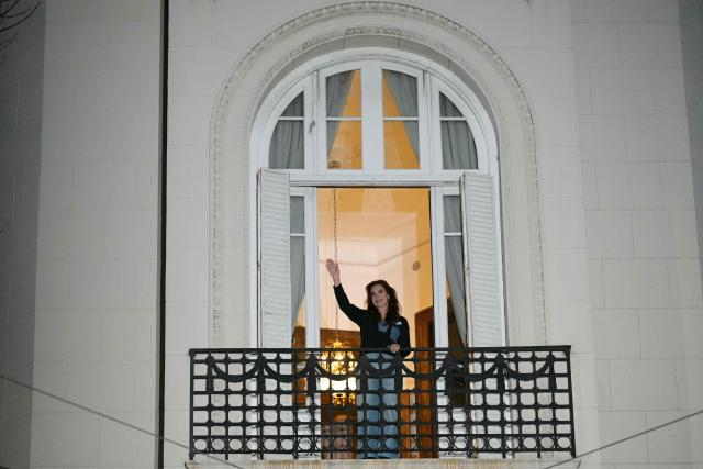 Former Argentine President and Vice President Cristina Fernandez de Kirchner waves to supporters from the balcony of her house arrest in Buenos Aires on September 1, 2026, during the fourth anniversary of the failed assassination attempt against her. (Photo by JUAN MABROMATA / AFP)