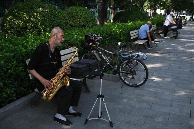 A man plays the saxophone at a park in Beijing on September 2, 2026. (Photo by Pedro PARDO / AFP)