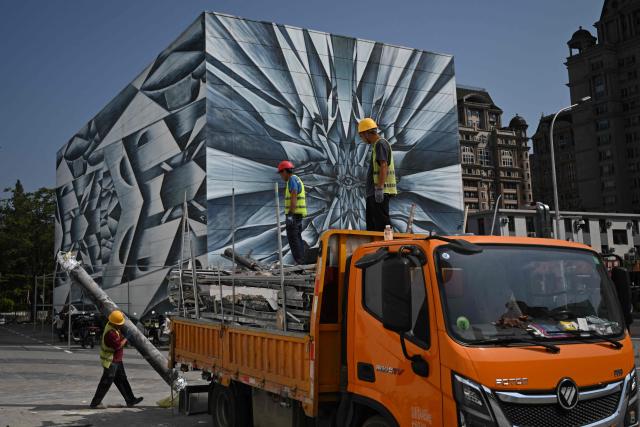 Construction workers load a flatbed truck in Beijing on September 2, 2026. (Photo by Pedro PARDO / AFP)