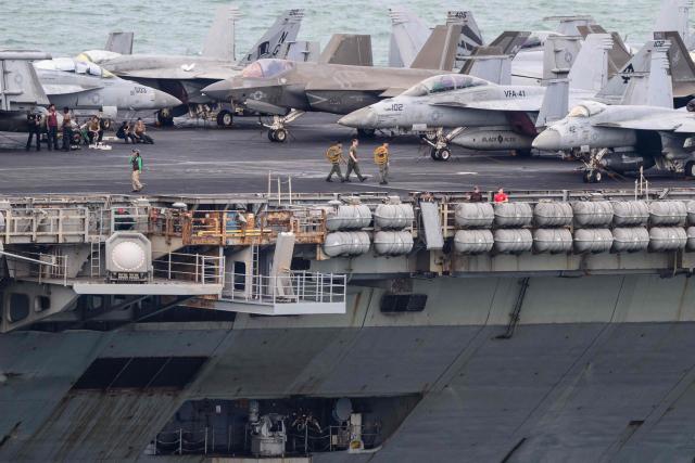 Crew members walk on the flight deck of US nuclear-powered aircraft carrier USS Abraham Lincoln (CVN-72) as it heads towards Laem Chabang Port, near the city of Pattaya on September 2, 2026. (Photo by ANTHONY WALLACE / AFP)