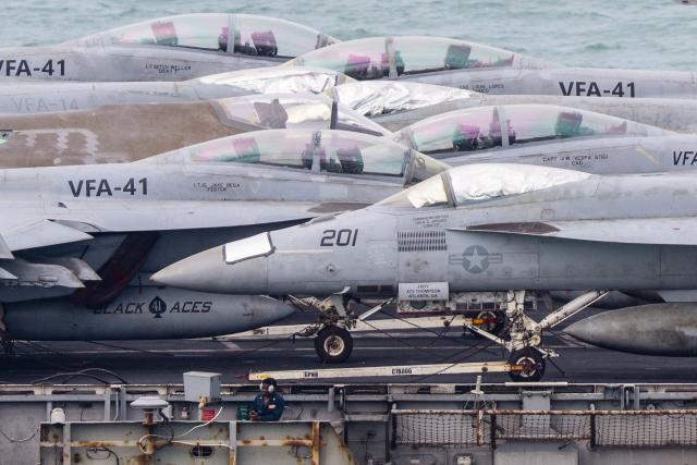 A crew member stands next to aircrafts on the flight deck of US nuclear-powered aircraft carrier USS Abraham Lincoln (CVN-72) as it heads towards Laem Chabang Port, near the city of Pattaya on September 2, 2026. (Photo by ANTHONY WALLACE / AFP)