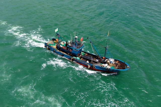 An areal view shows a fishing boat sailing out to sea from Jimiya Fishing Port in Qingdao West Coast New Area, in eastern China's Shandong province, on September 1, 2026, as the autumn fishing season begins following a four-month summer moratorium. (Photo by CN-STR / AFP) / China OUT