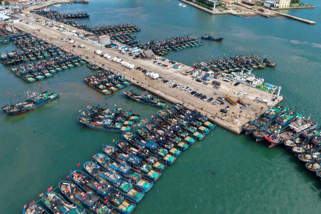An areal view shows fishing boats bearing Chinese flags seen at Jimiya Fishing Port in Qingdao West Coast New Area, in eastern China's Shandong province, on September 1, 2026, as the autumn fishing season begins following a four-month summer moratorium. (Photo by CN-STR / AFP) / China OUT