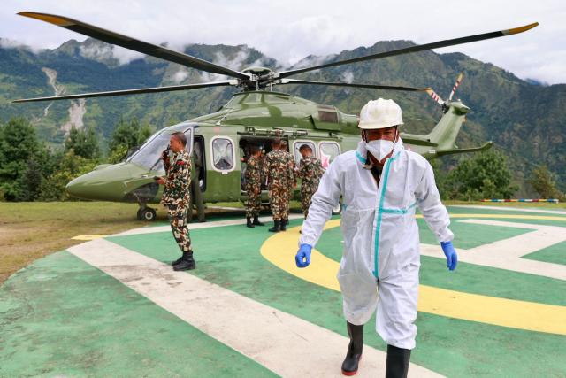 A Nepal Army helicopter carries dead bodies from the flood affected area in Nepal's Rasuwa district on September 2, 2026. Nepali families were holding symbolic funeral ceremonies to "liberate the souls" of loved ones missing since deadly flash floods swept away their villages and homes in the Himalayan region a week ago. (Photo by Prabin RANABHAT / AFP)