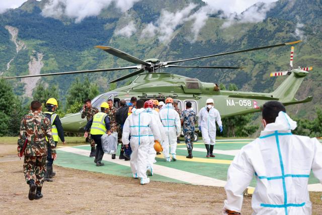 A Nepal Army helicopter carries dead bodies from the flood affected area in Nepal's Rasuwa district on September 2, 2026. Nepali families were holding symbolic funeral ceremonies to "liberate the souls" of loved ones missing since deadly flash floods swept away their villages and homes in the Himalayan region a week ago. (Photo by PRABIN RANABHAT / AFP)