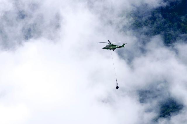 A Nepal Army helicopter carries dead bodies from the flood affected area in Nepal's Rasuwa district on September 2, 2026. Nepali families were holding symbolic funeral ceremonies to "liberate the souls" of loved ones missing since deadly flash floods swept away their villages and homes in the Himalayan region a week ago. (Photo by Prabin RANABHAT / AFP)