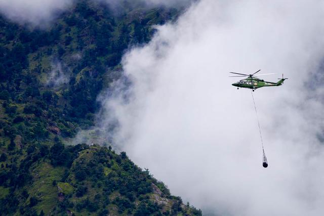 A Nepal Army helicopter carries dead bodies from the flood affected area in Nepal's Rasuwa district on September 2, 2026. Nepali families were holding symbolic funeral ceremonies to "liberate the souls" of loved ones missing since deadly flash floods swept away their villages and homes in the Himalayan region a week ago. (Photo by Prabin RANABHAT / AFP)