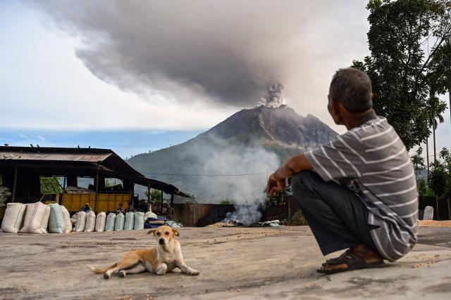 A man looks at Mount Sinabung spew ash and thick smoke as seen from Karo, North Sumatra province early on September 2, 2026. (Photo by Yt HARYONO / AFP)