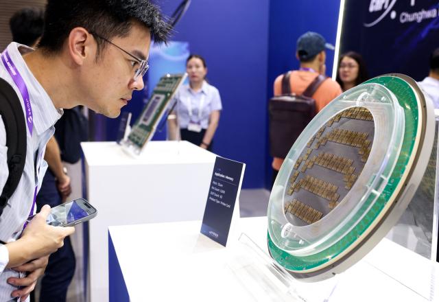A visitor looks at a probe card used for semiconductor memory testing at the booth of Taiwan's Chunghwa Precision Test Tech. Co., Ltd. (CHPT) during SEMICON Taiwan in Taipei on September 2, 2026. (Photo by I-Hwa Cheng / AFP)