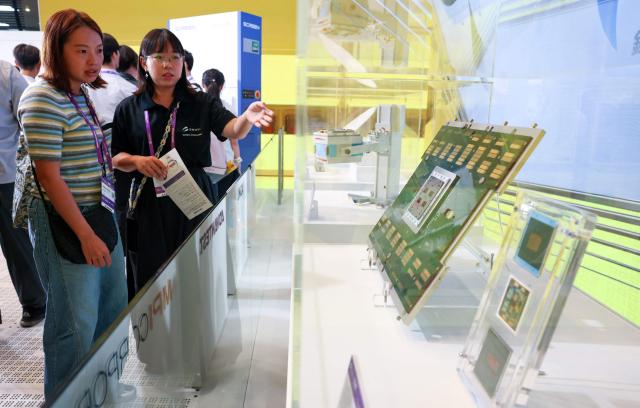 A visitor looks at semiconductor components during SEMICON Taiwan in Taipei on September 2, 2026. (Photo by I-Hwa Cheng / AFP)