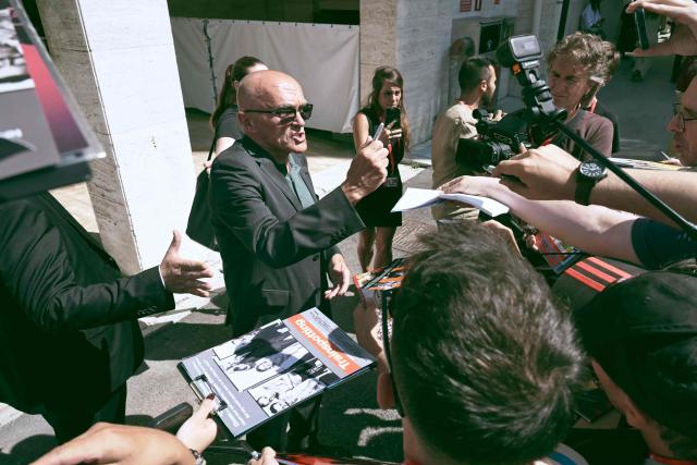 Director Danny Boyle signs autographs as he arrives to attend the photocall of the movie "Ink" presented at the 83rd International Venice Film Festival, at Venice Lido on September 2, 2026. (Photo by Stefano Rellandini / AFP)
