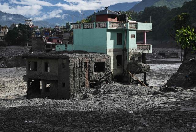 A turquoise-green house stands tall amid sludge near Trishuli river in the aftermath of flash floods at Trishuli Center in Nepal's Nuwakot district on September 2, 2026. Nepali rescuers searched on September 2, for survivors feared trapped inside hydropower tunnels a week after devastating floods, but hopes were fading as teams hit dead ends and no one was confirmed alive. (Photo by Arun SANKAR / AFP)