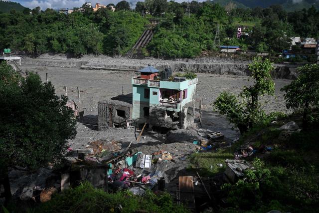 A turquoise-green house stands tall amid sludge near Trishuli river in the aftermath of flash floods at Trishuli Center in Nepal's Nuwakot district on September 2, 2026. Nepali rescuers searched on September 2, for survivors feared trapped inside hydropower tunnels a week after devastating floods, but hopes were fading as teams hit dead ends and no one was confirmed alive. (Photo by Arun SANKAR / AFP)