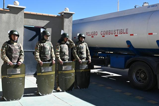 (FILES) Bolivian soldiers stand guard as tank trucks enter the state-owned Yacimientos Petrolíferos Fiscales Bolivianos (YPFB) Senkata plant, in El Alto, Bolivia, on June 21, 2026, a day after Bolivia's President Rodrigo Paz declared a state of emergency. The Bolivian government ordered temporary intervention of the state-owned oil company YPFB in order to "restore efficiency" to its management, amid a fuel supply crisis, according to a decree published in the official gazette on September 2, 2026. (Photo by AIZAR RALDES / AFP)