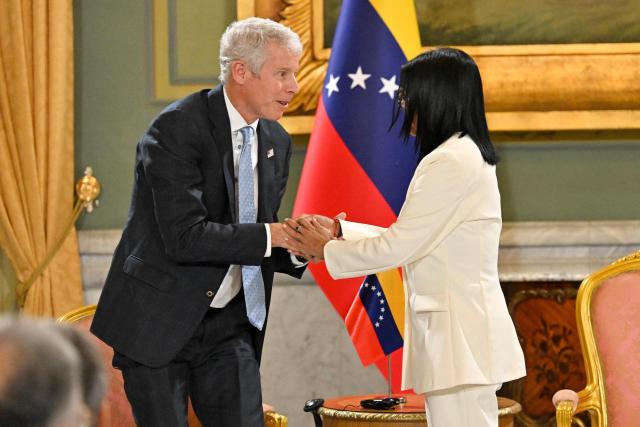 US Energy Secretary Chris Wright (L) and Venezuela's interim President Delcy Rodriguez (R) shake hands during the signing of an oil agreement at the Miraflores Presidential Palace in Caracas on September 2, 2026. US Energy Secretary Chris Wright visits Venezuela to finalize an agreement after US President Donald Trump announced that the United States will take a majority stake in 65 billion barrels of Venezuela's oil reserves, in what he described as "the largest oil deal in history." (Photo by Juan BARRETO / AFP)