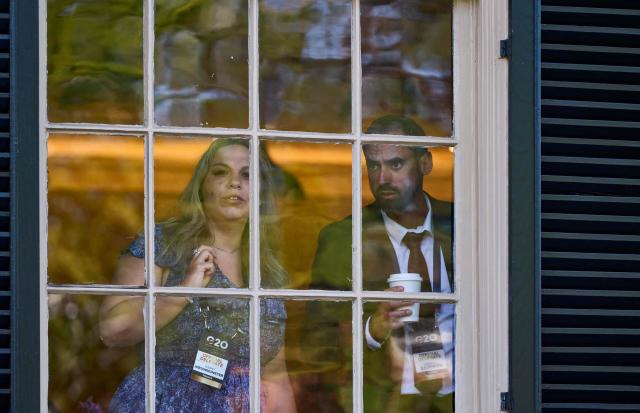 Delegates at the G20 Innovation Ministerial summit look out the window at protestors at the Carolina Inn in Chapel Hill, North Carolina, on September 2, 2026. (Photo by Matt RAMEY / AFP)