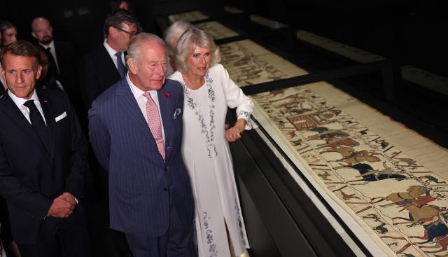 Britain's King Charles III and France's President Emmanuel Macron, accompanied by their wives Britain's Queen Camilla and Brigitte Macron (obscured) view sections of the Bayeux Tapestry during a preview event for the Bayeux Tapestry Exhibition, at the British Museum in London on September 2, 2026. (Photo by Adrian Dennis / POOL / AFP)