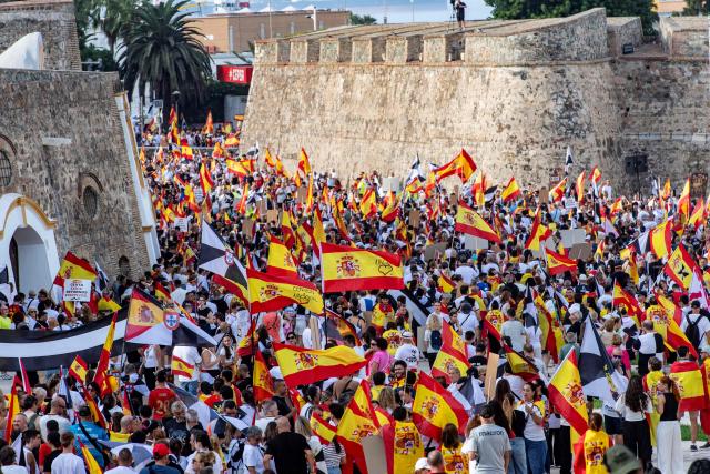Protesters hold Spain's flags during a demonstration to demand the return of normality one month after a mass influx of migrants in Ceuta on September 2, 2026, the annual Ceuta Day. Local anger divide Ceuta one month after the mass influx of migrants into the North African Spanish territory. 5,000 migrants according to the government, or at least 10,000, according to Ceuta authorities, remain in the small territory of 18.5 square kilometers and 80,000 inhabitants, wandering the streets in search of food and sleeping in streets and on beaches. (Photo by Antonio Sempere / AFP)