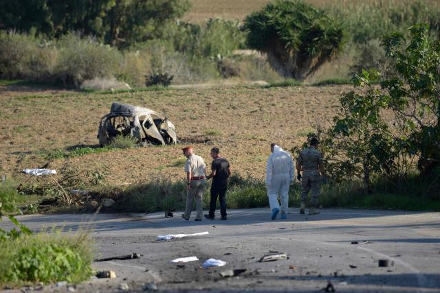 (FILES) Police and forensic experts inspect the wreckage of a car bomb believed to have killed journalist and blogger Daphne Caruana Galizia close to her home in Bidnija, Malta, on October 16, 2017. The force of the blast broke her car into several pieces and catapulted the journalist's body into a nearby field, witnesses said. She leaves a husband and three sons. A Maltese court on September 2, 2026 aquitted tycoon Yorgen Fenech of orchestrating the brutal murder in 2017 of investigative reporter Daphne Caruana Galizia, according to media reports. (Photo by AFP) / Malta OUT
