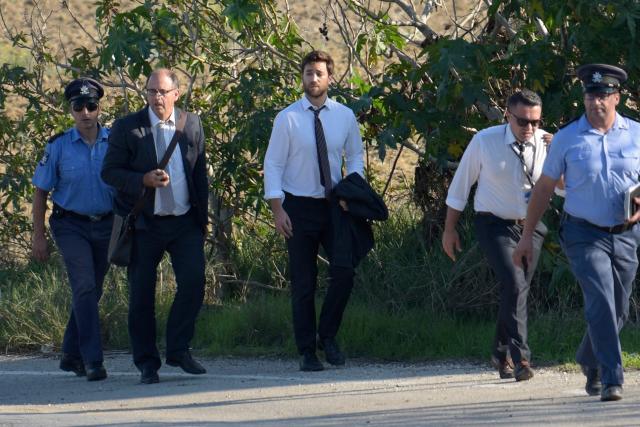 (FILES) ALTERNATIVE CROP AND ADDING NAMES - Matthew Caruana Galizia (C) and Peter Caruana Galizia (2ndL), son and husband of journalist Daphne Caruana Galizia and policemen walk past the wreckage of a car bomb that killed Daphne Caruana Galizia close to her home in Bidnija, Malta, on October 16, 2017. The force of the blast broke her car into several pieces and catapulted the journalist's body into a nearby field, witnesses said. She leaves a husband and three sons. A Maltese court on September 2, 2026 aquitted tycoon Yorgen Fenech of orchestrating the brutal murder in 2017 of investigative reporter Daphne Caruana Galizia, according to media reports. (Photo by AFP) / Malta OUT / ALTERNATIVE CROP
