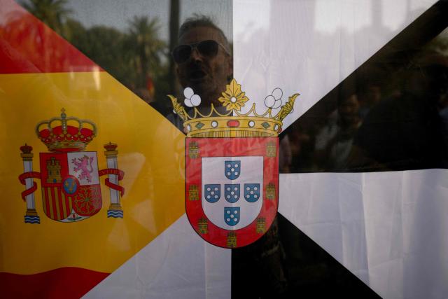 Protesters holding a Spanish and Ceuta flag take part in a demonstration one month after a mass influx of migrants in Ceuta, in Malaga, on September 2, 2026. Local anger divide Ceuta one month after the mass influx of migrants into the North African Spanish territory. 5,000 migrants according to the government, or at least 10,000, according to Ceuta authorities, remain in the small territory of 18.5 square kilometers and 80,000 inhabitants, wandering the streets in search of food and sleeping in streets and on beaches. (Photo by JORGE GUERRERO / AFP)